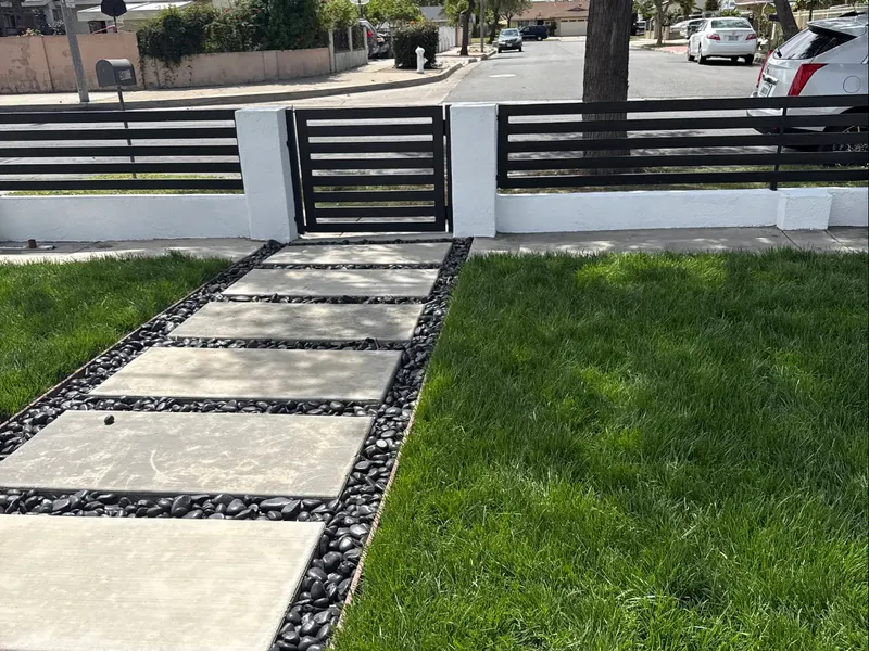Commercial property frontage in Orange County with a new paver walkway, pebble border, and fresh sod